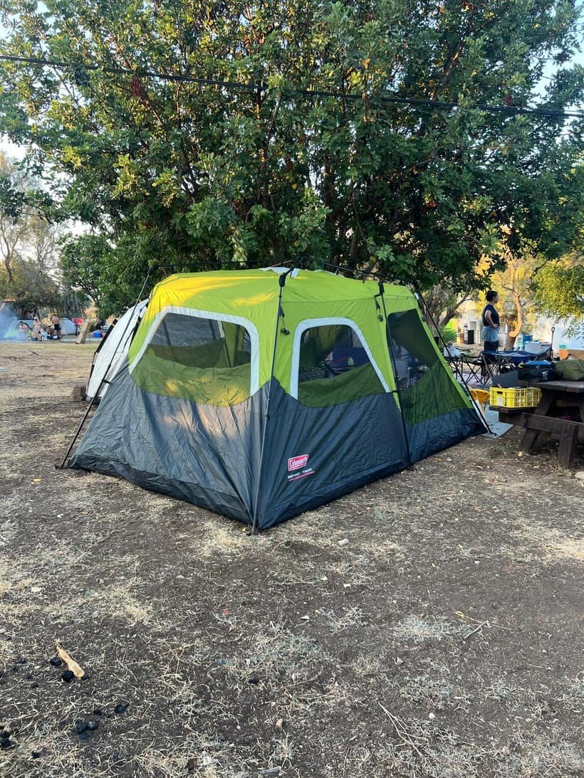 אוהל משפחתי פרוס בחניון קמפינג מתחת לעץ